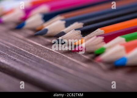 Colored multi colored pencils close up macro down on a vintage wooden background. Stock Photo