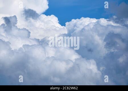 Large white clouds with thunderstorms in the blue sky. Stock Photo