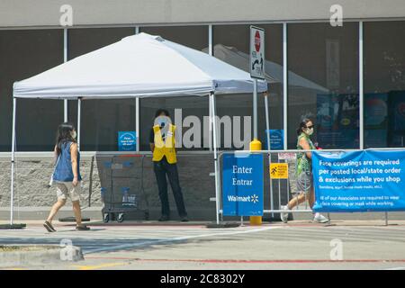 Plano, USA. 20th July, 2020. Customers wearing face masks enter a Walmart store in Plano, Texas, the United States, on July 20, 2020. The world's largest retailer Walmart has announced that Walmart and Sam's Club shoppers in the United States will be required to wear face coverings starting July 20. In addition to posting clear signs at the front of stores, Walmart has created the role of Health Ambassador and will station them near the entrance to remind those without a mask. Credit: Dan Tian/Xinhua/Alamy Live News Stock Photo