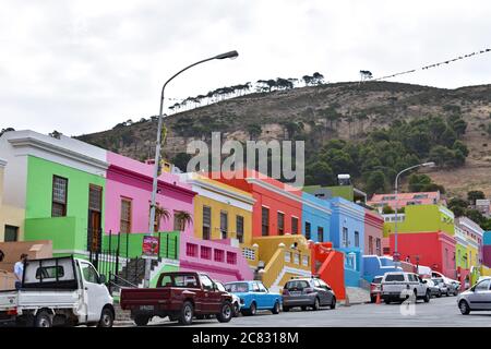 The brightly coloured houses of the Bo-Kaap area (Malay Quarter) of Cape Town, South Africa. View of the street with cars parked in front of the homes Stock Photo