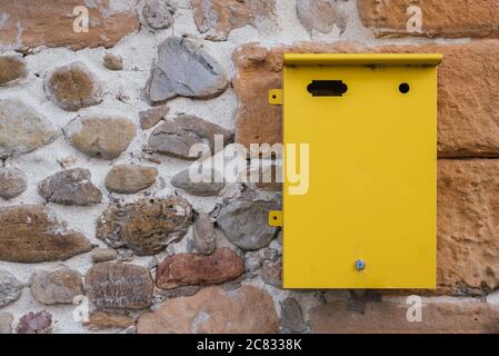 Yellow metallic letterbox attached on the wall Stock Photo