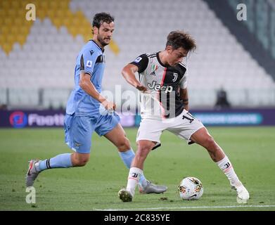 Turin, Italy. 20th July, 2020. FC Juventus' Paulo Dybala (R) vies with Lazio's Marco Parolo during the Serie A football match in Turin, Italy, July 20, 2020. Credit: Federico Tardito/Xinhua/Alamy Live News Stock Photo