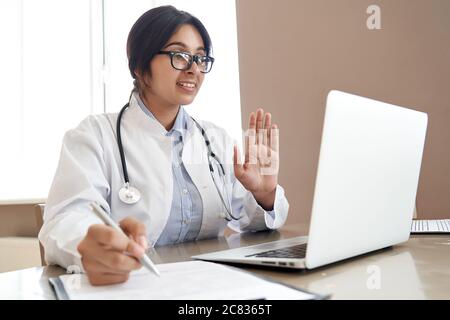 Indian female doctor talk to patient by telemedicine online webcam video call. Stock Photo