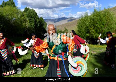 (200721) -- BEIJING, July 21, 2020 (Xinhua) -- Nyima and his apprentices perform Jiuhe Zhuo dance in Jiuhe Village of Qonggyai County in Shannan, southwest China's Tibet Autonomous Region, July 1, 2020. Jiuhe Zhuo dance, originated in Qonggyai County of Shannan, has a history of more than 1,300 years. It has been a favorite dancing form for local people in Shannan to pray for good luck since ancient times and was dubbed waist drum dance in Tibet. Nyima, an inheritor of Jiuhe Zhuo dance, which is a national intangible cultural heritage, began to learn the dance from his father at the age of ni Stock Photo