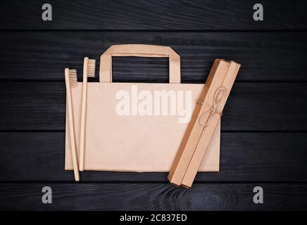 Flatlay eco natural kraft paper bag and bamboo toothbrushes on black Stock Photo