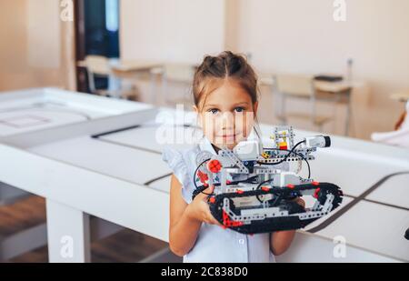 Schoolgirl holding constructor robot in robotics class Stock Photo