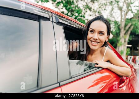 Confident young Hispanic brunette woman looking at train carriage on station platform in Bangkok, Thailand Stock Photo