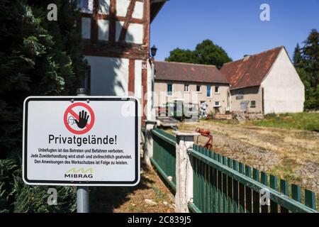 13 July 2020, Saxony, Pödelwitz: A sign "Private property of the Mibrag" hangs on an abandoned farm. The place in the Leipzig brown coal district wants to become a showcase project of structural change. Pödelwitz was actually supposed to be dredged, but considers itself saved after the coal exit. A large part of the inhabitants left the village years ago, only eight of 40 plots are still inhabited. (to dpa "In the dump - A village reinvents itself after the coal is out") Photo: Jan Woitas/dpa-Zentralbild/dpa Stock Photo
