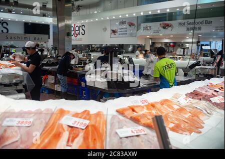 26.09.2019, Sydney, New South Wales, Australia - Fish sellers behind a counter at a stall inside the Sydney Fish Market at Blackwattle Bay in Pyrmont. Stock Photo