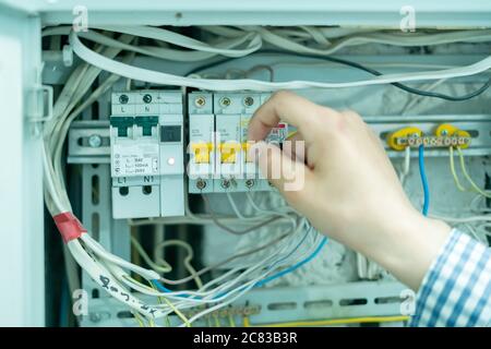 professional electricity worker fixing the home lighting power problem, swithing the power panel Stock Photo