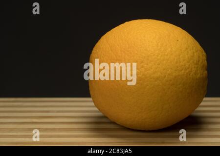 Three fresh orange on circle wood tray with dark Stock Photo