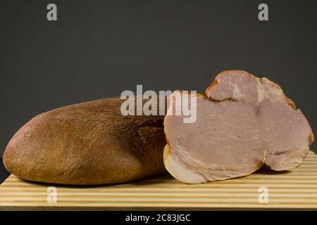 Sliced ham on wooden cutting board. Fresh prosciutto. Stock Photo