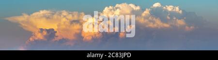 the formation of storm clouds illuminated by the setting sun-panorama Stock Photo