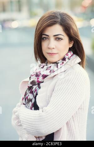 Confident woman arms folded looking at camera outdoors Stock Photo