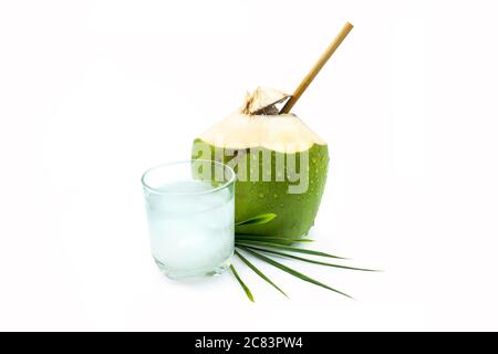 A glass of coconut water with green coconut on a white background. Stock Photo