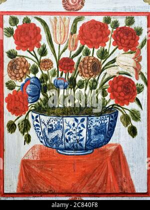 Fragment of the ancient plastered wall in Saint Francis church in Evora, Portugal. Red flowers in pot on the table. Beautiful example of the portugues Stock Photo