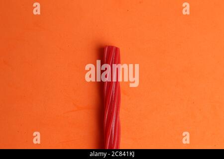 High angle shot of a bunch of a stick candy isolated on an orange surface Stock Photo