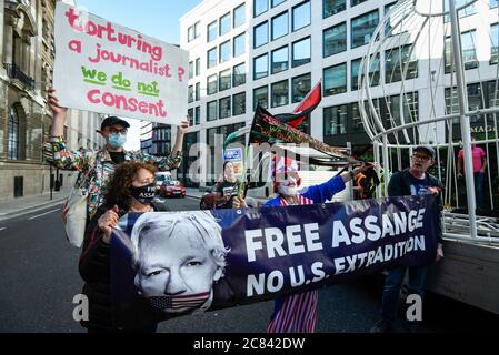 London, UK.  21 July 2020. Supporters of Julian Assange in attendance as Dame Vivienne Westwood is being harnessed into a giant birdcage and suspended 10 feet in the air in front of The Old Bailey Criminal Court in protest about the U.S. extradition trial of Julian Assange, which is to recommence at the Old Bailey on 7 September.  She is dressed in a yellow trouser suit, enacting the metaphor of ‘The Canary In Coal Mine’, which is indicative of 'Assange being sacrificed for identifying ‘poison’ in the system'.   Credit: Stephen Chung / Alamy Live News Stock Photo