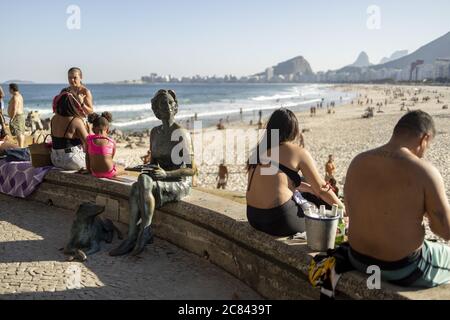 RIO DE JANEIRO, BRAZIL - Jul 12, 2020: Copacabana boulevard and beach with people around the bronze statue of Clarice Lispector, Ukranian journalist a Stock Photo