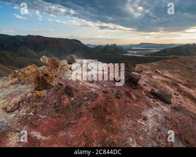 Colorful rhyolit red and orange fumarole at foot of Brennisteinsalda mountain with panorma of Landmannalaugar. Area of Fjallabak Nature Reserve in Stock Photo