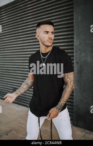 European tattooed hip male in a sporty outfit with red and black shorts and  shirt Stock Photo - Alamy