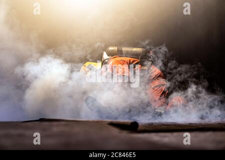Firefighter check and rescue a man in building with smoke from fire inside. Firefighter safety rescue from accident and public service concept. Stock Photo