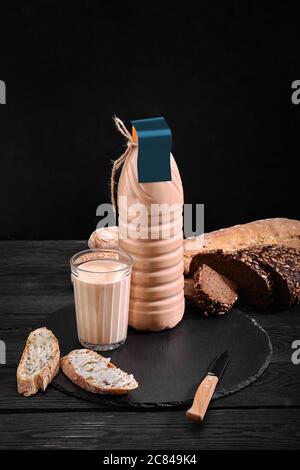 Homemade fermented baked milk in transparent bowl on an old dark background. Rustic. Milk products. Background image, copy space