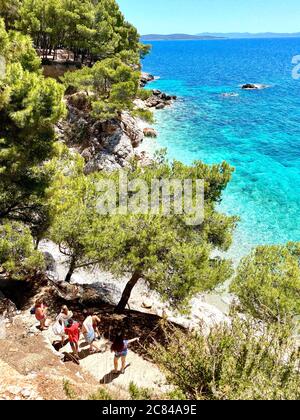 The beautiful crystal clear blue waters of the Adriatic Sea.  The path leads down to Jagodna Beach on Hvar Island, Croatia. Looking oveKorcula Island. Stock Photo