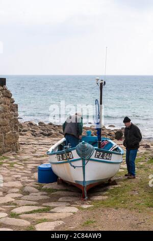 Two fishermen working on their boat, Penberth Cove, Penwith Peninsula, Cornwall, UK Stock Photo