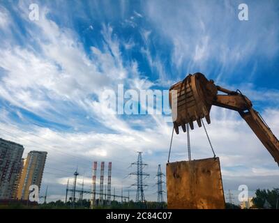 Bucket loader lifting metal panel with blue sky on background. Fisheye lens shot Stock Photo