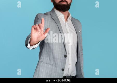 Unrecognizable businessman pushing button on virtual screen against blue background, space for design Stock Photo