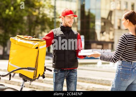 Courier Delivering Order To Customer Giving Pizzas Boxes Outdoors Stock Photo
