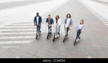 Five friends having a nice ride on electric kick scooters Stock Photo