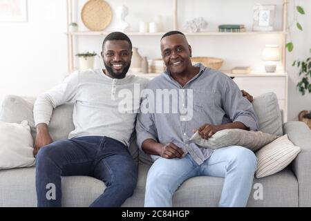 Portrait With Dad. Happy Black Man Posing With Mature Father At Home Stock Photo
