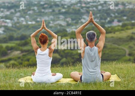 Anonymous couple meditating in ssummer spring nature