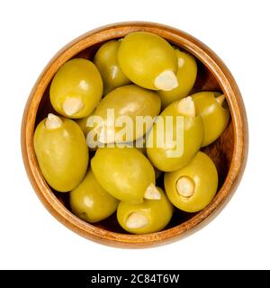 Almond stuffed green olives in wooden bowl. Big European olives, fruits of Olea europaea, hand filled with pickled crunchy almonds. Stock Photo