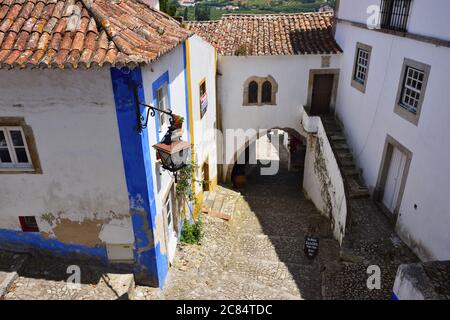 Obidos, Portugal - June 1, 2017: Charming medieval street of the old town Obidos in Portugal. Vila de Obidos national monument. Casa do Arco da Cadeia Stock Photo