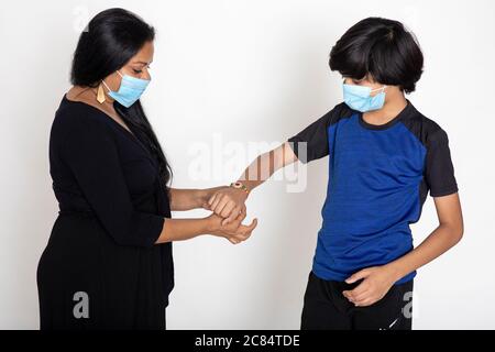 Indian woman ties Rakhi on her brother's hand on the occasion of Raksha Bandhan, You boy and woman wearing Covid protection masks Stock Photo