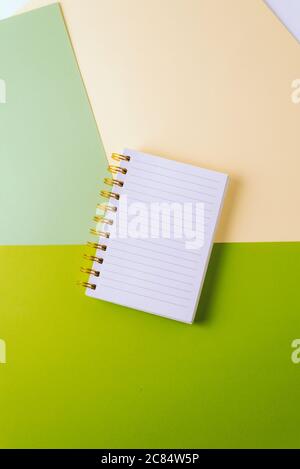 Open notebook with blank sheet and golden spiral on a colorful pastel background. The concept of education, writing down ideas, plans. Place for text. Stock Photo
