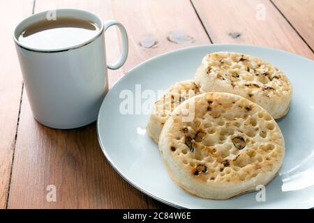 Tea and crumpets on a rustic wooden table Stock Photo
