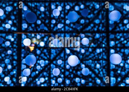 Many illuminated balls hung and linked by threads creating an infinite perspective as abstract blue background Stock Photo