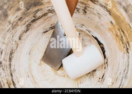 Empty mortar bucket at bricklayer workstation - mallet and trowel - work shift over Stock Photo