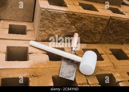 Trowel and mallet - working tools of a professional bricklayer in the workplace Stock Photo