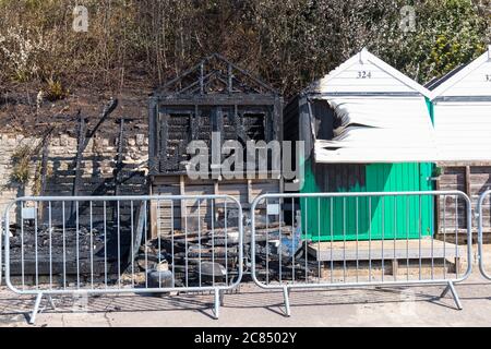 Bournemouth, Dorset UK. 21st July 2020. Aftermath of fire at West Cliff beach, Bournemouth which started in beach hut, showing remains of skeletal charred remains of beach hut with damage to neighbouring ones and charred remains of cliffside behind.  Credit: Carolyn Jenkins/Alamy Live News Stock Photo