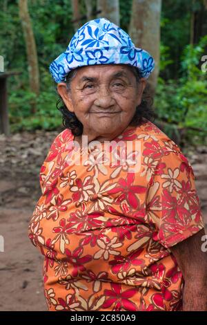 Portrait shot of an elderly Brazilian lady in a blue and white hated wearing a flowered dress, in Alter do Chao, Para State, Brazil