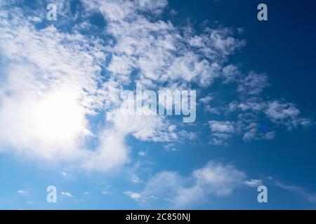 Cirrus clouds in a blue sky, taken on a summer day. the sun shines through a cloud. Stock Photo