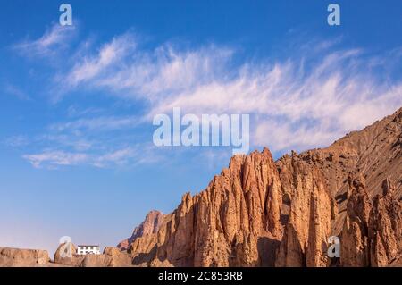 Bizarre rocks and white house on the background of magical blue sky with clouds. Spiti valley, India Stock Photo