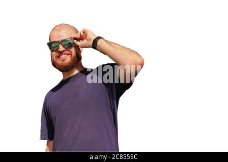 Young bald adult with ginger beard and black reflective sunglasses laughing and enjoying him self cut out on white background Stock Photo