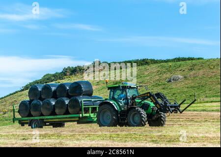Timoleague, West Cork, Ireland. 21st July, 2020. On a day of hot, sunny weather and highs of 22 degrees Celsius, Michael and Richard McCarthy bale silage on their farm in Timoleague, West Cork. Credit: AG News/Alamy Live News Stock Photo