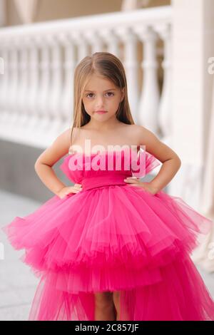 Cute little girl model in fluffy pink dress posing to photographer Stock Photo Alamy